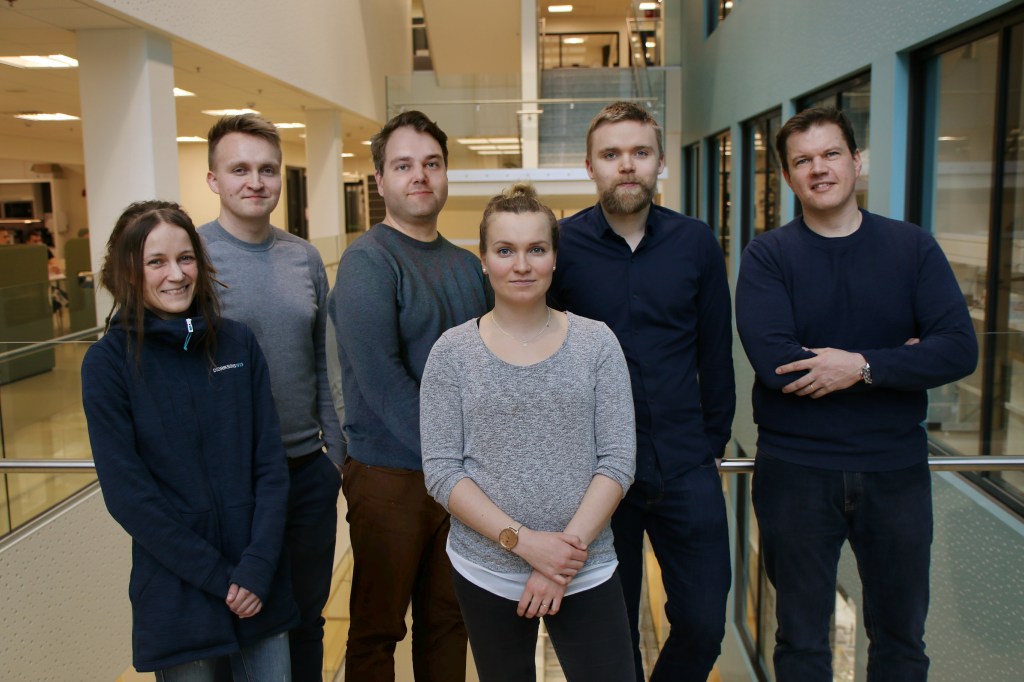 A group photo of 6 people in front of a staircase.